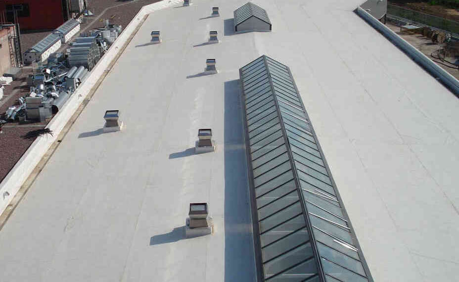 A flat white commercial roof with multiple skylights and ventilation units arranged in rows, ideal for projects that also require repair fascia and soffit work.